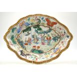 A Chinese Canton famille rose shaped dish decorated with figures in a garden,