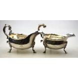 A George III pot-bellied sauce boat, with cut rim and scroll handle, on hoof feet,