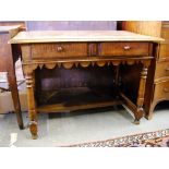 An antique alpine fruitwood side table having two frieze drawers over a wavy edged apron,