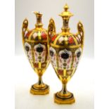 A pair of Royal Crown Derby twin handle urns decorated in the Imari style, pattern 1128,