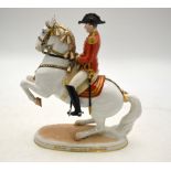 A Vienna porcelain model of a dancing Lipizzaner horse and rider raised on an oval base inscribed