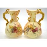 A matched pair of Royal Worcester blush ground jugs decorated with wild flowers,