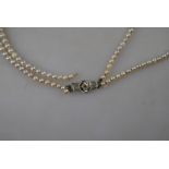 A two-row graduated cultured pearl necklace, on 9ct snap set with rose diamond,