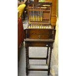 An oak canteen of cutlery on barley twist stand