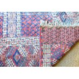 An antique Turkoman Hatchli rug, circa 1900, the four panel geometric design on soft red ground, 1.