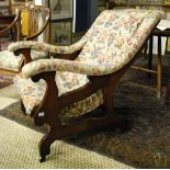 A Victorian mahogany framed upholstered open armchair on brass castors