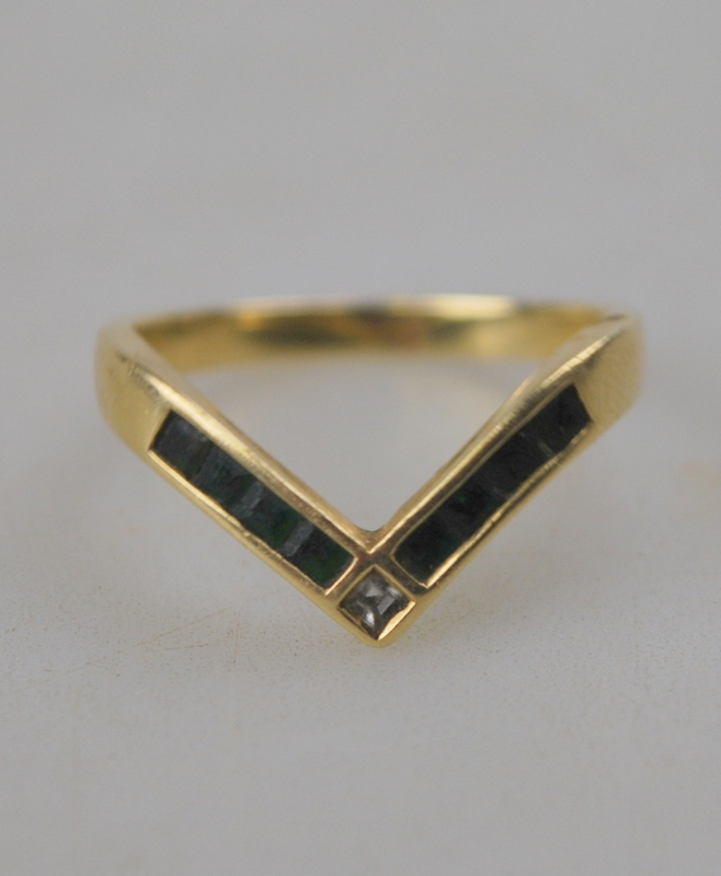 A yellow metal emerald and diamond-set w