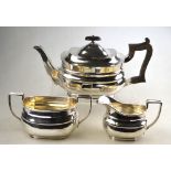 A heavy quality silver three piece tea service of oblong form with composite handle and finial,