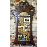A 19th century fret cut walnut framed wall mirror having an arched plate,