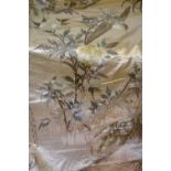 A large Chinese ivory silk panel depicting Asiatic exotic birds perched on flowering prunus,