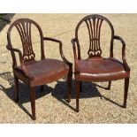 A pair of mahogany framed 19th century carvers each with studded brown leather overstuffed seats