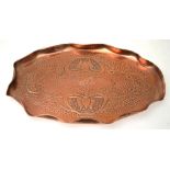 An Art Nouveau Newlyn-style copper small oval tray with rippled rim and stylised floral design,