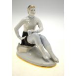 An Art Deco style Lomonosov porcelain model of a seated skater, rubbed marks to base, 17 cm h.