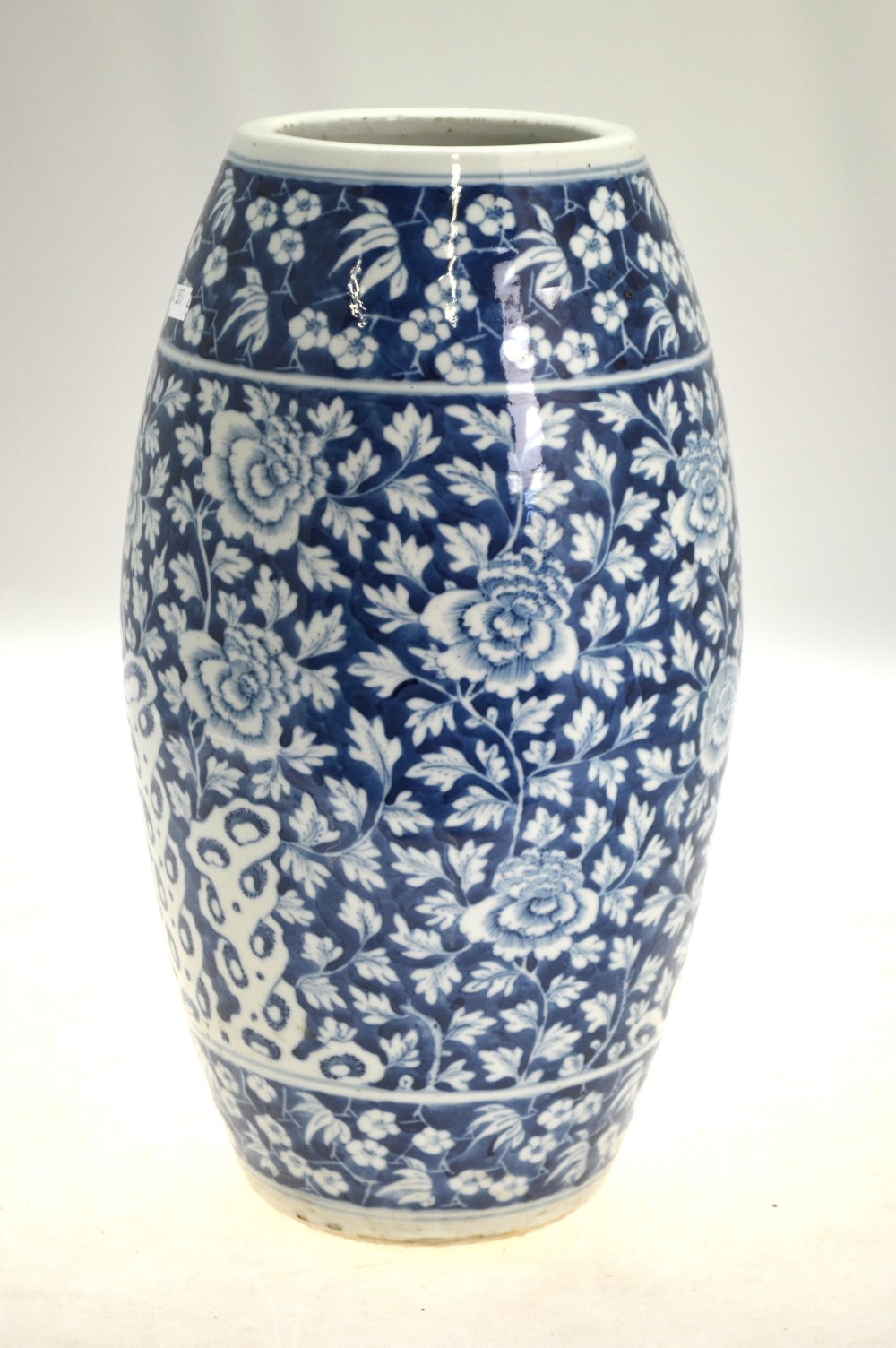 A Chinese blue and white slim barrel shaped vase decorated with peony, flowers,
