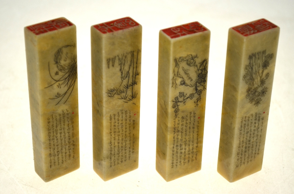 Four Chinese rectangular hardstone seals incised with calligraphy above flowers and foliage,