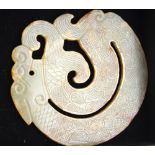 A Chinese jade pendant of circular form carved as a dragon with incised scales, 5.