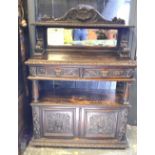 A late 19th century mirror backed carved oak buffet having two tiers over a pair of moulded