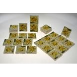 Twenty-eight Mintons Art Nouveau small square tiles decorated with a stylised yellow flower and