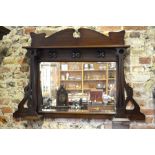An Art & Crafts period walnut framed bevel edged overmantel in the mirror of Liberty & Co mounted