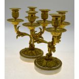 A good pair of 19th century ormolu three branch table candelabra, raised on circular marble bases,