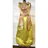 An Edwardian shell pink and acid yellow silk brocade skirt and boned bodice edged with pink ostrich