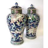 A pair of Chinese late 19th century polychrome vases, dark blue ground decorated with phoenix,