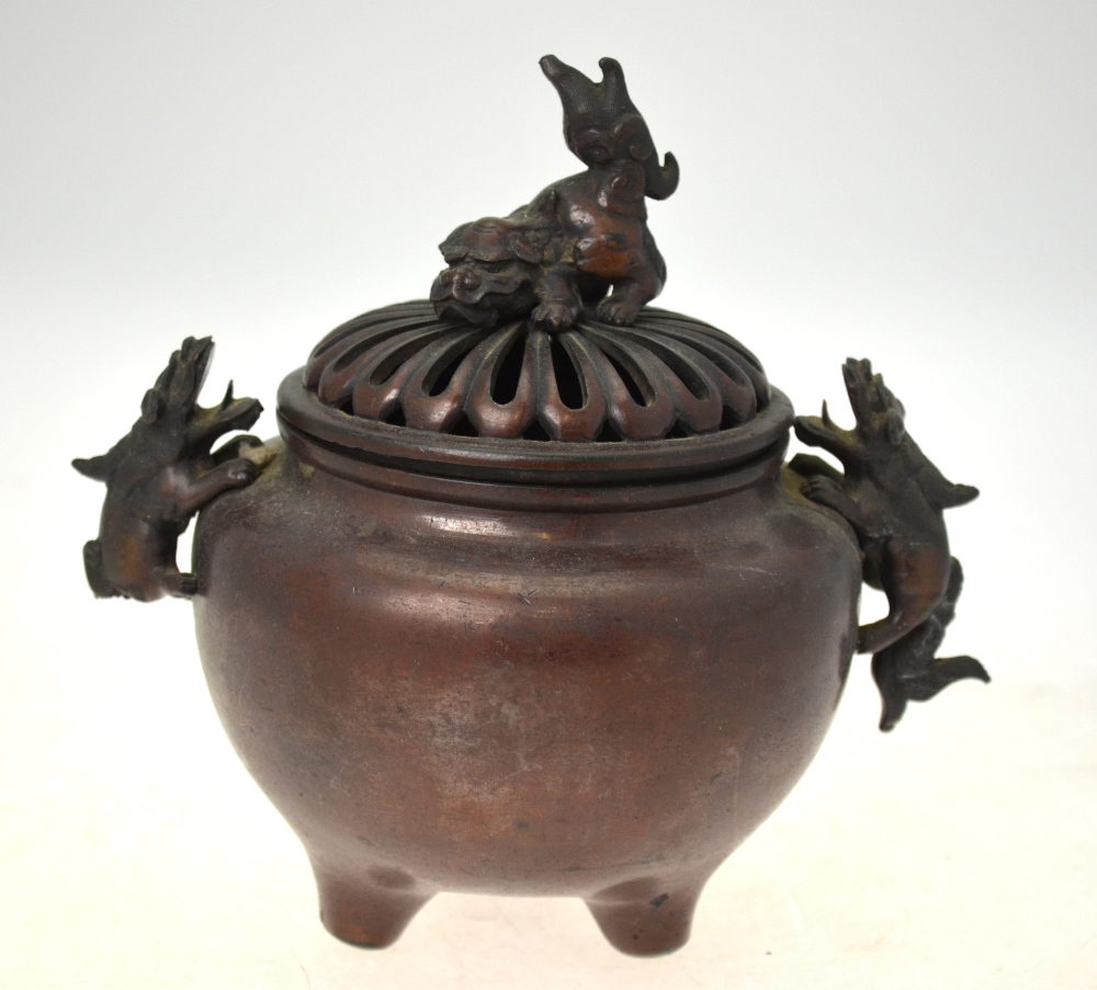 A Japanese bronze spherical censer on three feet with two handles formed as Shi Shi,