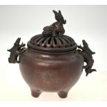 A Japanese bronze spherical censer on three feet with two handles formed as Shi Shi,