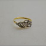 A three stone brilliant cut diamond crossover ring in illusion and millgrain setting with three