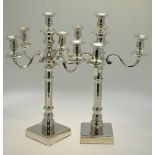 A pair of electroplated five-sconce candelabra with turned pillars and square bases,