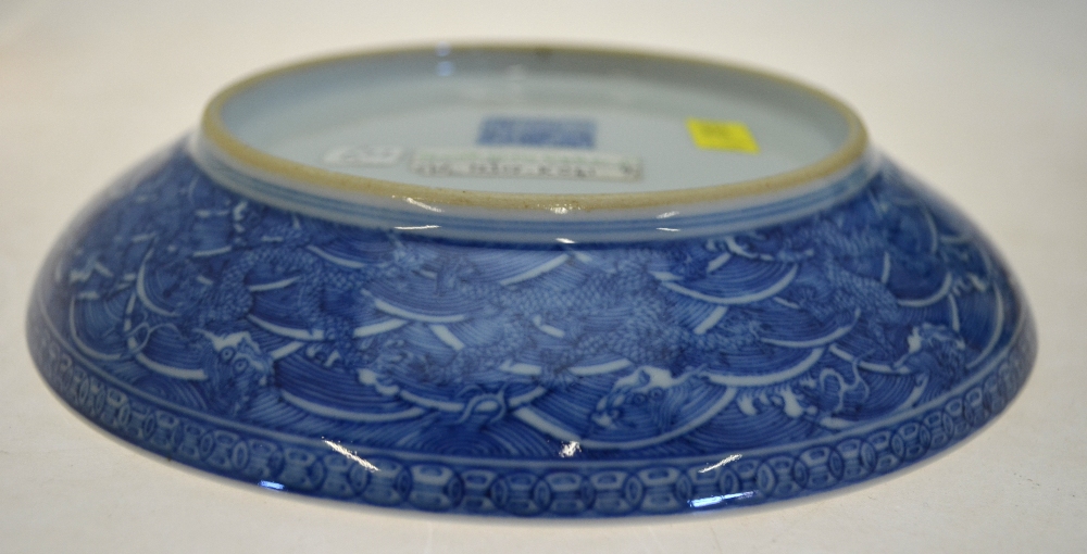 A Chinese blue and white saucer dish decorated to the centre with a dragon amongst waves, - Image 6 of 8