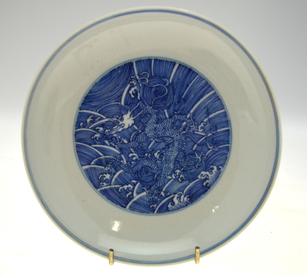 A Chinese blue and white saucer dish decorated to the centre with a dragon amongst waves, - Image 3 of 8