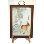 A Chinese porcelain famille rose rectangular panel decorated with a deer beneath a flowering tree