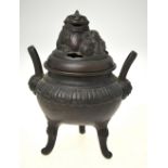 A Chinese bronze censer raised on three feet, having lug handles terminating with masks,