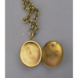 A large Victorian gilt metal hinged locket with applied monogram on Victorian cable style chain