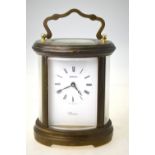 A Swiss Swiza 'Windsor' oval brass carriage clock with bevelled glass curved panels,