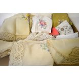 Three boxes of assorted table linen to include linen tablecloths with crocheted edges,