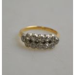 A double row diamond ring set with twelve diamonds in white millgrain setting on yellow gold shank