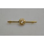 A diamond cluster bar brooch set with rose cut diamonds in yellow metal claw setting