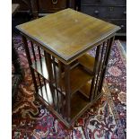 An Edwardian mahogany/walnut revolving bookcase raised on a cross platform to castors