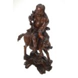 A Chinese hardwood carving of an immortal riding a fabulous animal, 35 cm h., c.