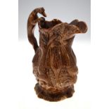 A 19th century brown glazed jug moulded with game - rabbits, ducks, fox, etc.