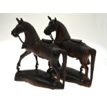 A pair of carved hardwood horses raised on shaped plinth bases, each 31.