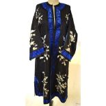 An early 20th century Chinese black silk robe worked in ivory silk depicting flowering prunus,