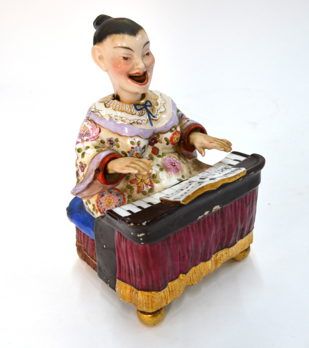 A Dresden-style Chinoiserie figure of a seated piano player with articulated head and arms,