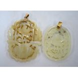 Two green jade pendants of reticulated form: one decorated with a flower arrangement;