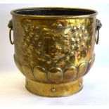 A 19th century Continental brass log bin with lion-mask and ring handles and embossed armorial