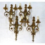 A set of four wall sconces with scrolling twin sconces surmounted by putti with pan-pipes,