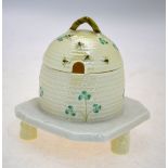 A Belleek honey pot or condiment jar with domed cover and loop handle finial,