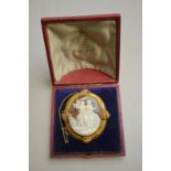 A Victorian oval shell cameo brooch of classical scene of bloomed yellow gold mount with vine leaf